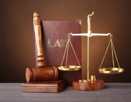 Judge gavel, scales and book on wooden table